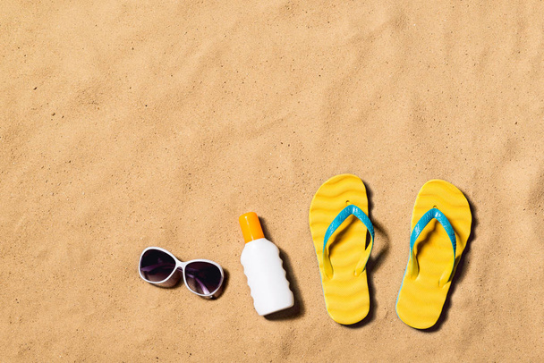 Summer vacation composition. Flip flops, sunglasses and sunscree - Photo, Image