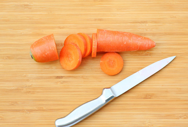 Cutting Carrot for cooking on wood block - Valokuva, kuva