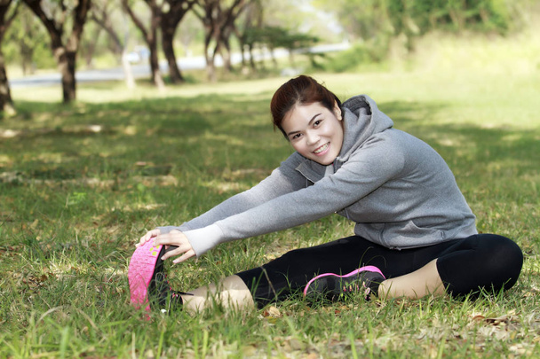 Atletik kadın Asya ısınma ve oturan genç kadın atlet  - Fotoğraf, Görsel