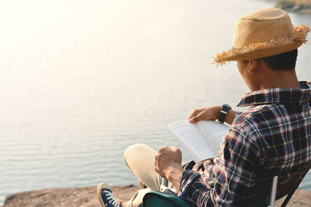 Happy Asian hipster man reading a book in nature background - Foto, Imagen
