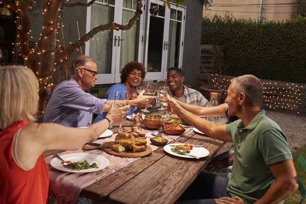 Mature Friends Enjoying Outdoor Meal - Photo, Image