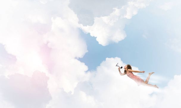 woman with megaphone flying high in sky - Photo, Image
