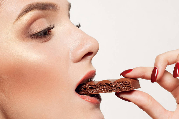Lovely smiling teenage girl eating chocolate - Фото, зображення