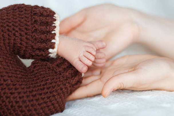 Newborn baby's feet on mom hands. - Photo, Image