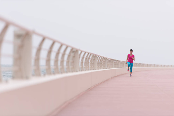 woman busy running on the promenade - Фото, изображение