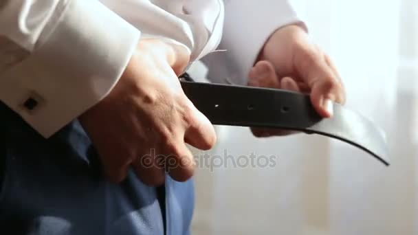 Mann schnallt Gürtel an seine Hose - Filmmaterial, Video