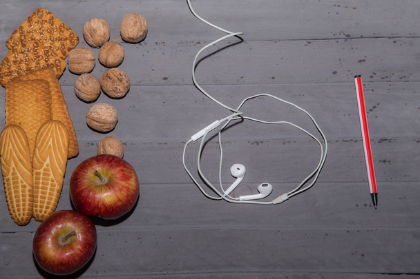 Печиво, волоські горіхи, яблука та вушні кіоски на столі. Вид зверху
 - Фото, зображення
