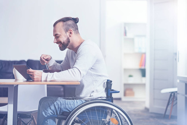 man sitting on wheelchair and enjoying breakfast - Foto, Bild
