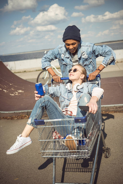 Teenagers having fun with shopping cart  - Foto, Imagen