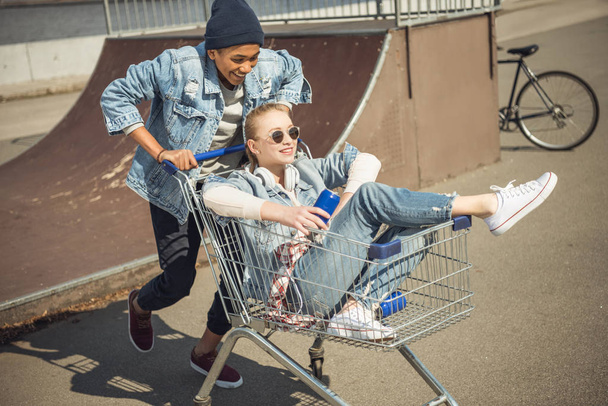 Teenagers having fun with shopping cart  - Zdjęcie, obraz