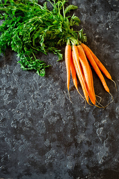Fresh carrots on a black background - Fotó, kép