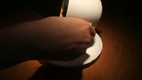 Adivinhar na área do café, uma mão feminina segurando uma caneca de café com motivos de café. Close-up
. - Filmagem, Vídeo