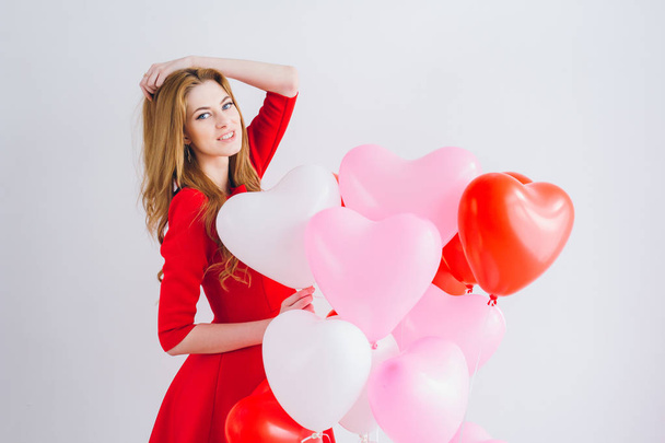 Girl in red dress with balloons in the shape of a heart - Foto, immagini
