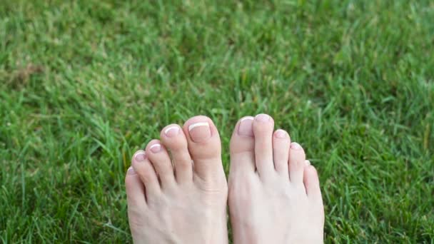 Ноги женщины на зеленой траве на лугу
 - Кадры, видео