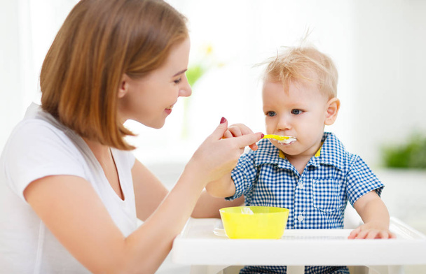 Mother feeds baby from spoon - Foto, imagen