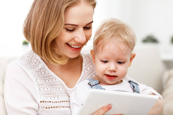Mère et bébé fils avec un ordinateur tablette à la maison
 - Photo, image