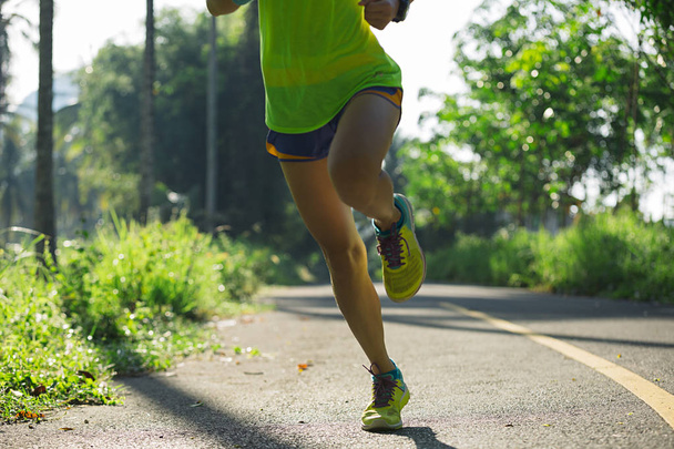 спортивна молода жінка біжить по лісовій стежці
  - Фото, зображення