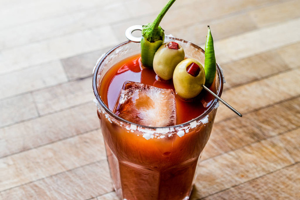 Bloody Mary Cocktail with green olive, pepper, salt and ice. - Фото, изображение