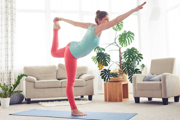 Розслаблена жінка робить йогу на йозі килимок у вітальні
 - Фото, зображення