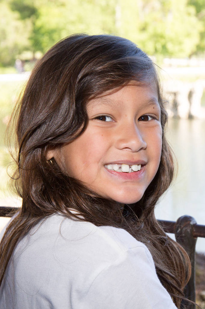 chica de diez años de origen indio en el borde del agua
 - Foto, imagen