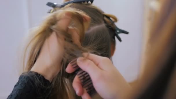 Profesjonalny salon fryzjerski robi fryzurę dla młode ładne kobiety - Materiał filmowy, wideo