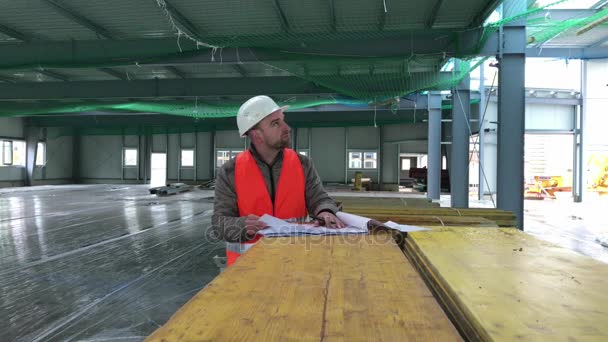Supervisor de construcción con plan en el sitio
 - Metraje, vídeo