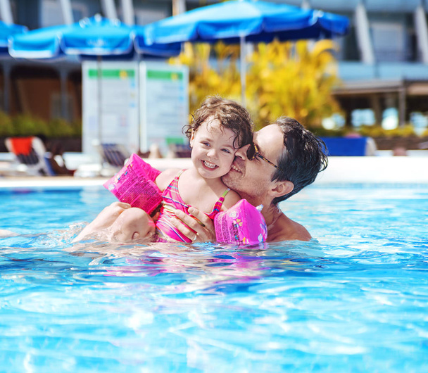 Handsome dad swimming with a cute daughter - Photo, Image