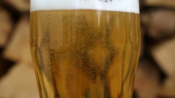 крупним планом склянка пива перед дровами на обертовій пластині
 - Кадри, відео