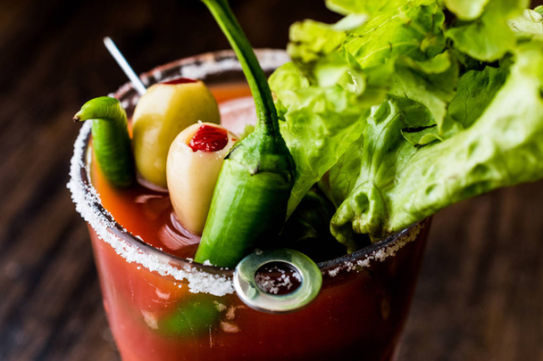 Bloody Mary Cocktail with green olive, pepper, lettuce, salt and ice - 写真・画像