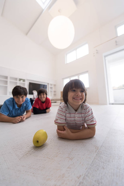 boys having fun with an apple on the floor - 写真・画像