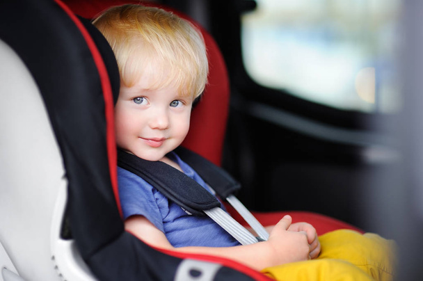 Portrait of pretty toddler boy sitting in car seat - Foto, imagen