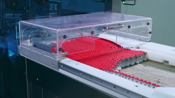 工場労働者は、医薬品の生産ラインから医療ボトルを取る - 映像、動画