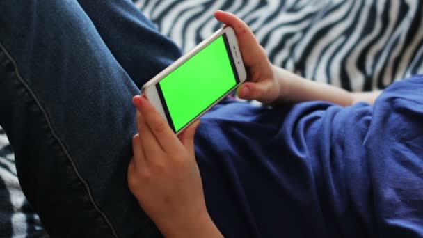 A gazdaság érintőképernyős készüléket, tinédzser részlete kezét, használ egy okos telefon. chroma-kulcs green screen - Felvétel, videó