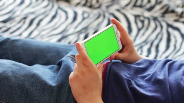 Tiener met Smartphone chroma key surfen op Internet op Bank thuis - Video