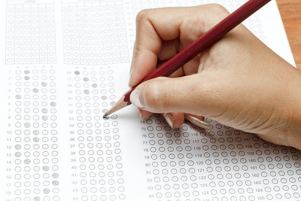 hand van vrouwen houden van potlood op gestandaardiseerde testformulier met Antw - Foto, afbeelding