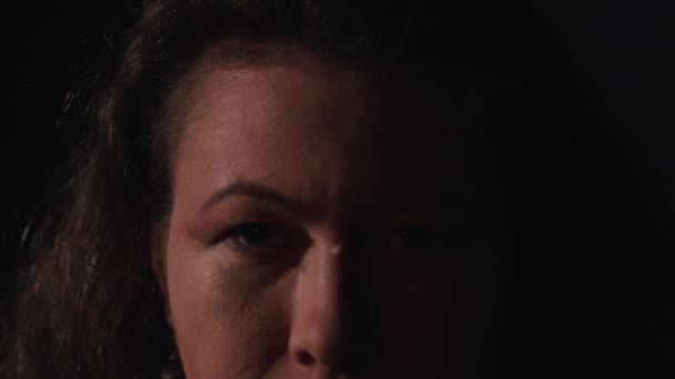 Brunette femme sérieuse avec verrue sur le nez et boucle d'oreille en or légèrement sourit
 - Séquence, vidéo