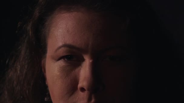 Bruneta žena vážné s bradavici na nos a zlaté náušnice pohledu do kamery - Záběry, video