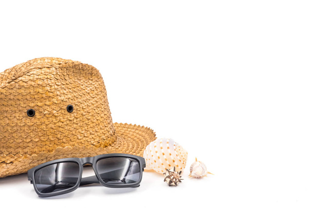 Шляпа с солнцезащитными очками и ракушками на белом фоне
 - Фото, изображение