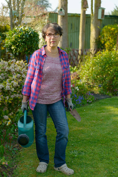 жінка садівництво в її красивому саду
.  - Фото, зображення