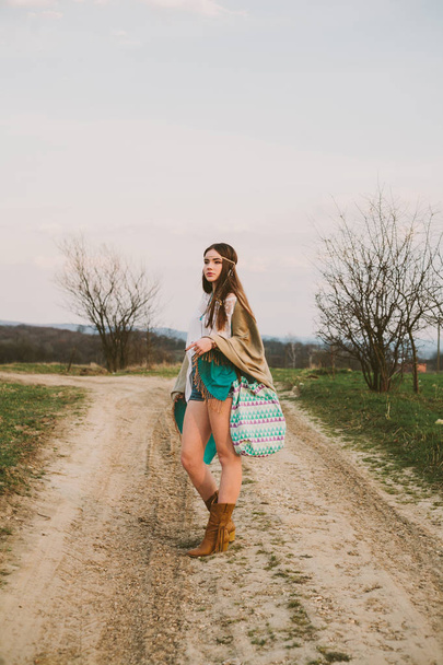 Hipster menina de pé em uma estrada de terra
 - Foto, Imagem