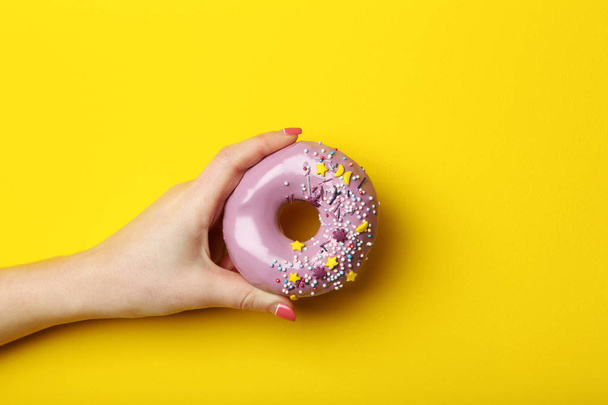 Female hand holding donut  - Zdjęcie, obraz