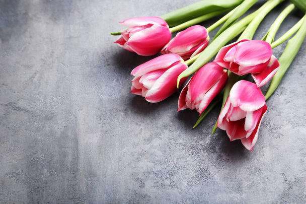 Bouquet of pink tulips on grey wooden table - Zdjęcie, obraz