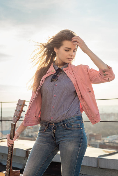 young beautiful woman with a guitar on the roof - Fotografie, Obrázek
