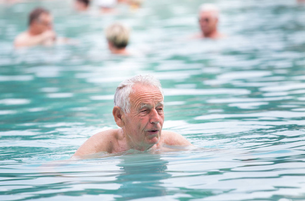 Senior man in het zwembad - Foto, afbeelding