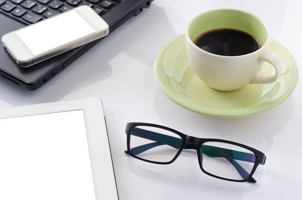 Glasses on the desk with a laptop and coffee cup. - Φωτογραφία, εικόνα