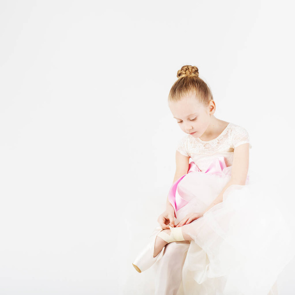 Krásné baletní tanečník izolovaných na bílém pozadí. Malá baletka šaty nebo sundá její pointe. - Fotografie, Obrázek