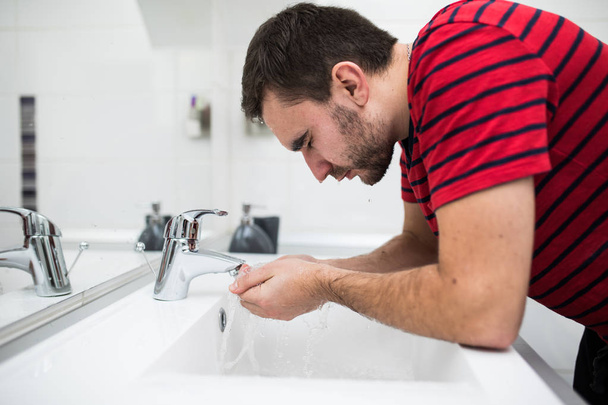 Muž mytí obličeje v koupelně umyvadlo - Fotografie, Obrázek