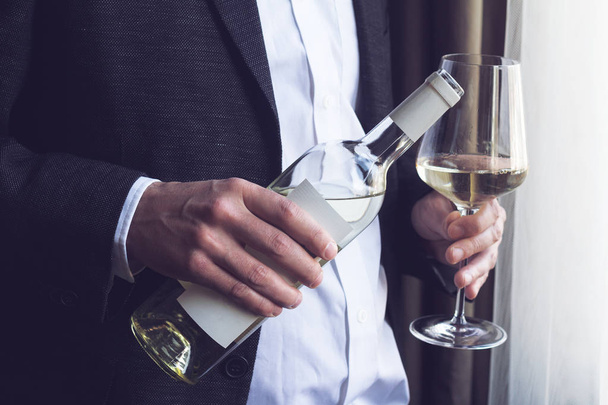 άνθρωπος ρίχνει λευκό κρασί σε ποτήρι - Φωτογραφία, εικόνα