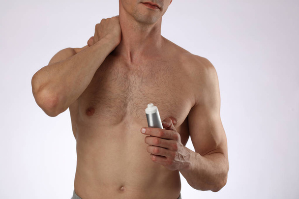 Man applying pain relieving cream, gel. Sport injury, Man with back, neck pain. Pain relief and health care concept. - Фото, изображение