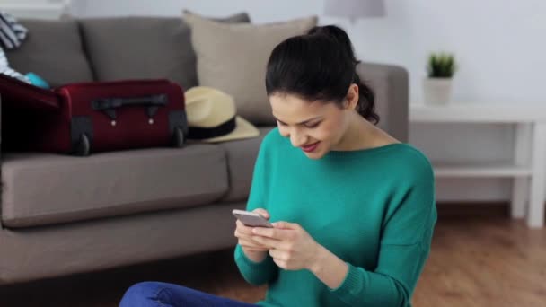 woman with smartphone at home going to travel - Metraje, vídeo